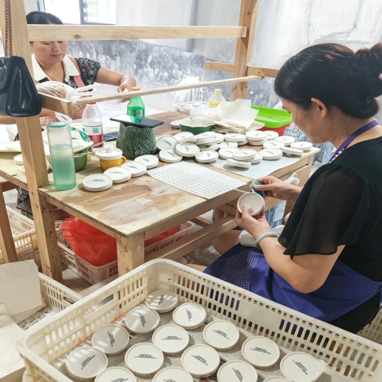 Artisan hand-painting ceramic decoration in Dehua workshop