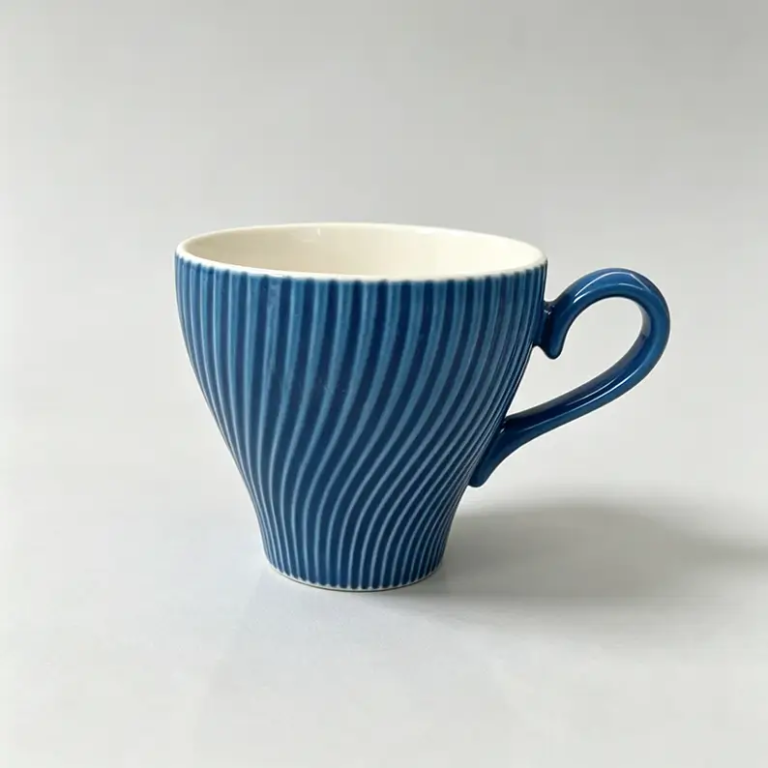 052g Blue spiral-textured ceramic coffee cup and saucer.