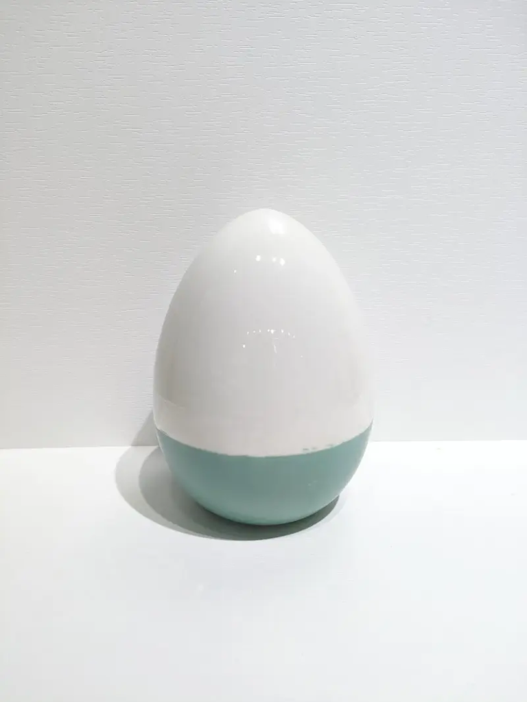 115D Two-tone egg-shaped ceramic ornament combining soft blue and white sections for a clean Easter decorative display.