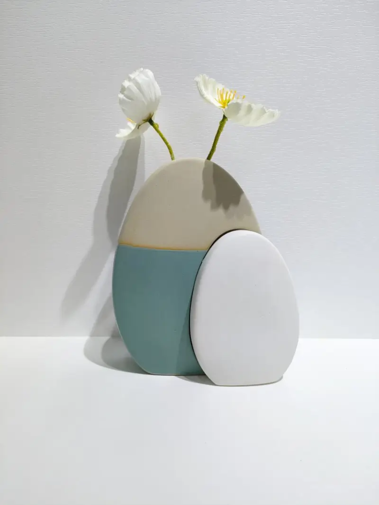 118DTwo-tone egg-shaped ceramic flower holder in blue and white with an open top for displaying fresh or decorative flowers in Easter settings.