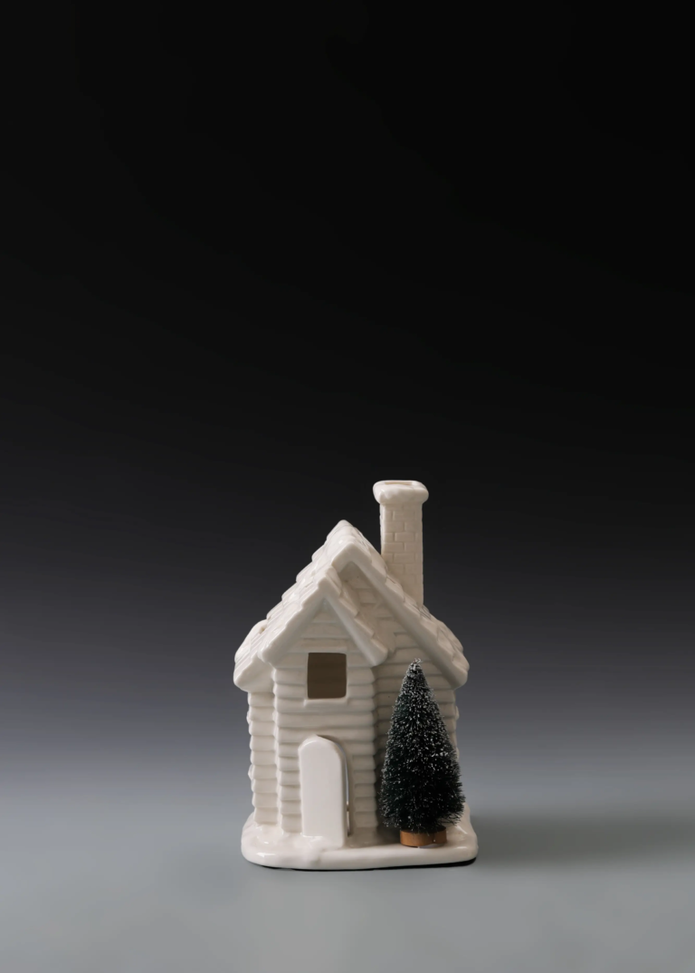 212A pine tree cottage in matte white ceramic with pine tree details and illuminated openings for Christmas village decor