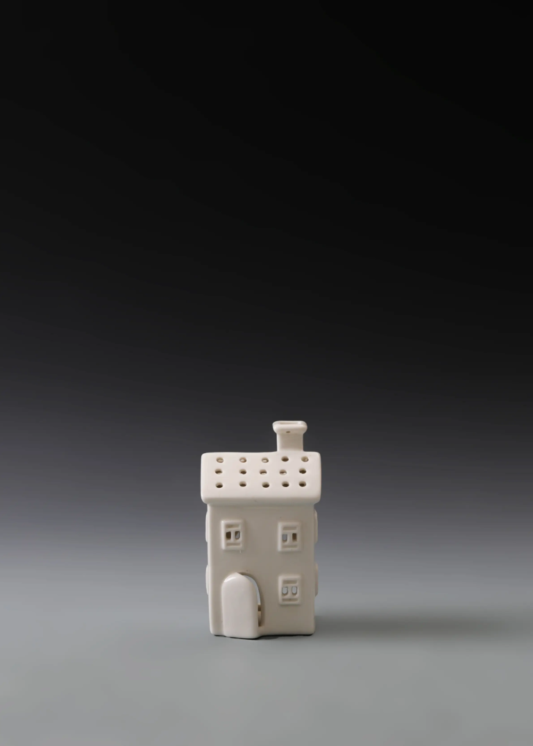 218A compact door house in matte white ceramic with a defined entrance and illuminated openings for holiday displays