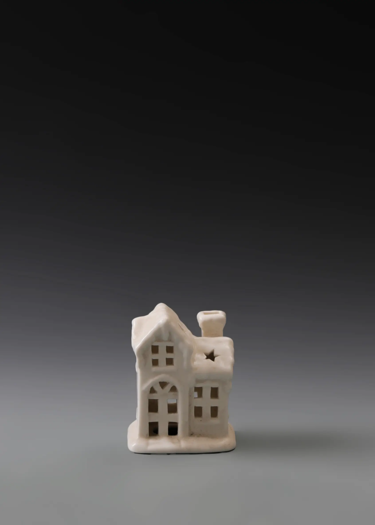 222A twin gable house in matte white ceramic featuring connected gable roof forms and illuminated openings.