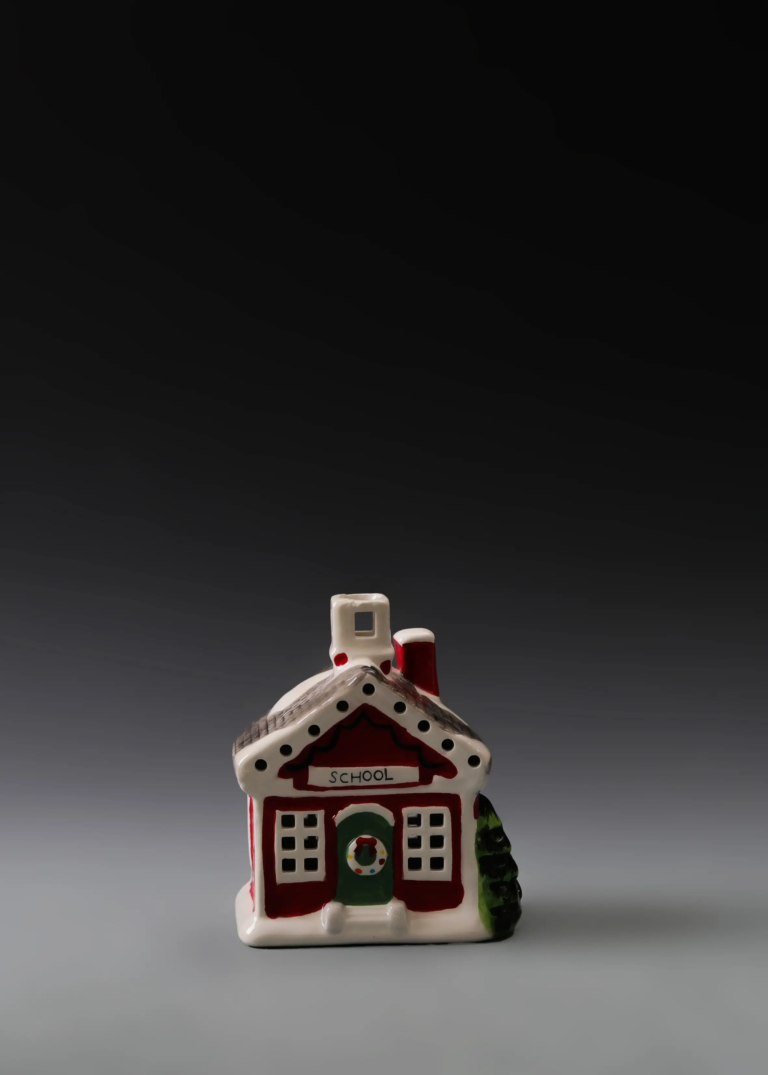 225A red holiday schoolhouse in hand-painted multicolor ceramic with festive details and illuminated windows