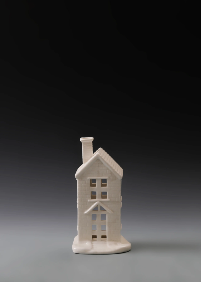 234A slim townhouse in matte white ceramic with a narrow facade, multiple windows and illuminated openings