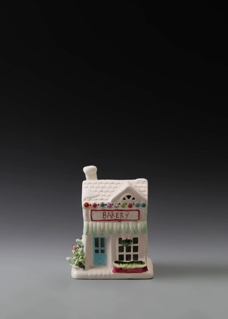 235A holiday bakery house in hand-painted multicolor ceramic with a festive storefront and illuminated windows.
