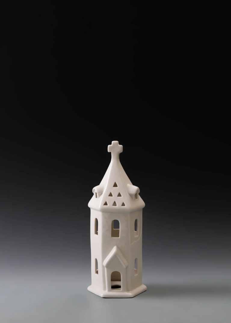 236A tall Gothic tower house in matte white ceramic with a pointed tower, cross detail and illuminated openings.