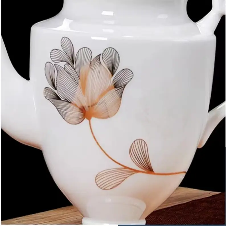Close-up of the floral decal decoration on the glossy white porcelain teapot, highlighting the delicate floral pattern and fine detailing.
