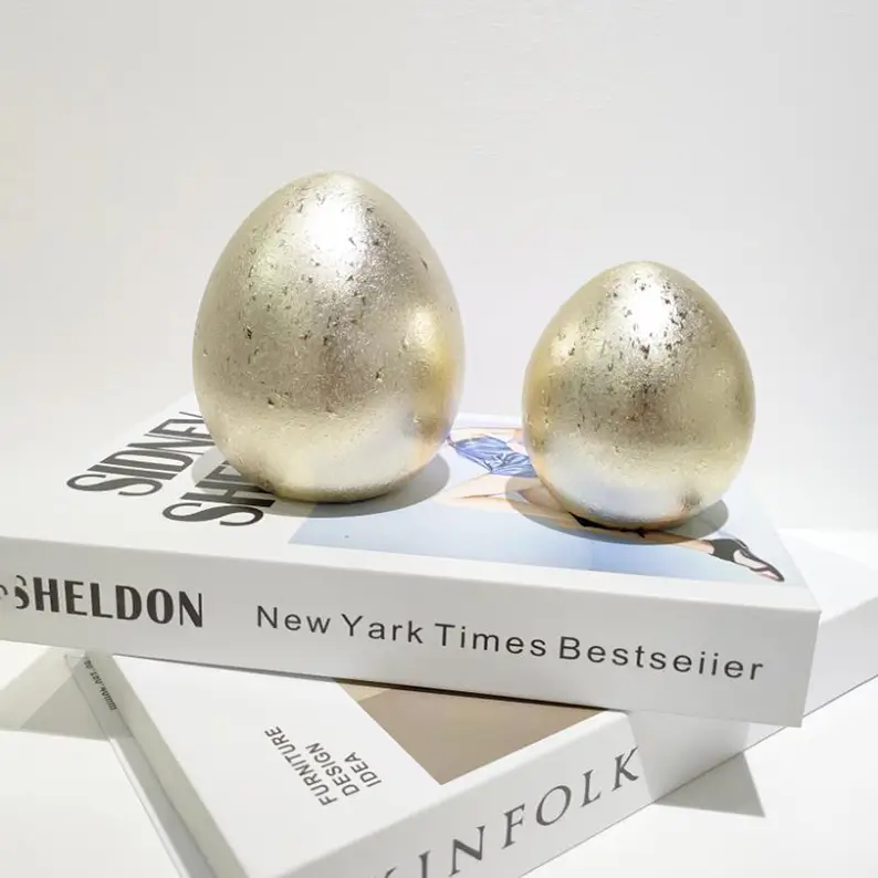 Easter ceramic display featuring an antique gold speckled egg ornament with a distinctive metallic surface effect for seasonal decoration.