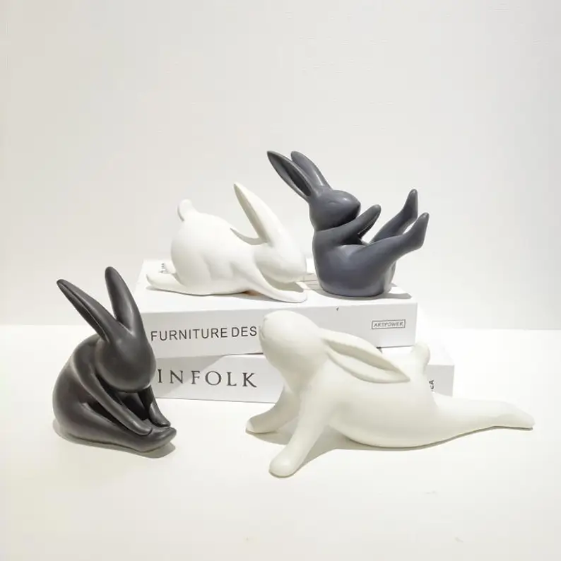 Black and white ceramic rabbit sculptures with different yoga postures creating artistic decorative displays for contemporary spaces