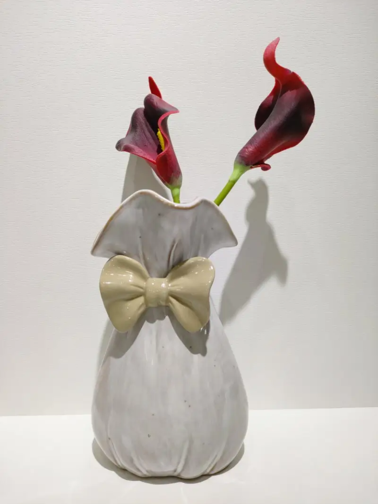 006D Bow embellished ceramic vase featuring a decorative silhouette and reactive glaze surface effect