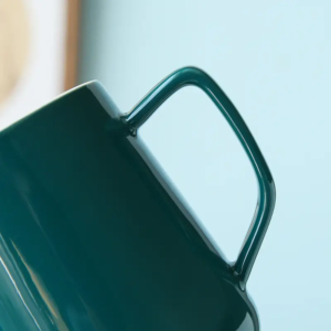Close-up view of ceramic mug showing smooth glazed surface and refined handle structure details.