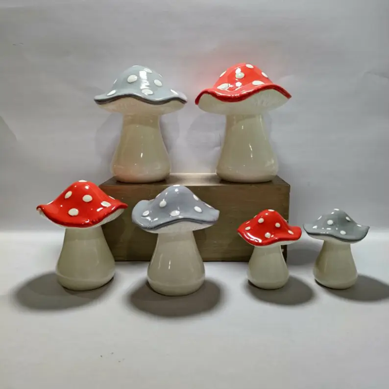 Ceramic mushroom figurines in multiple sizes with coordinated designs, suitable for layered display in residential and commercial interiors.