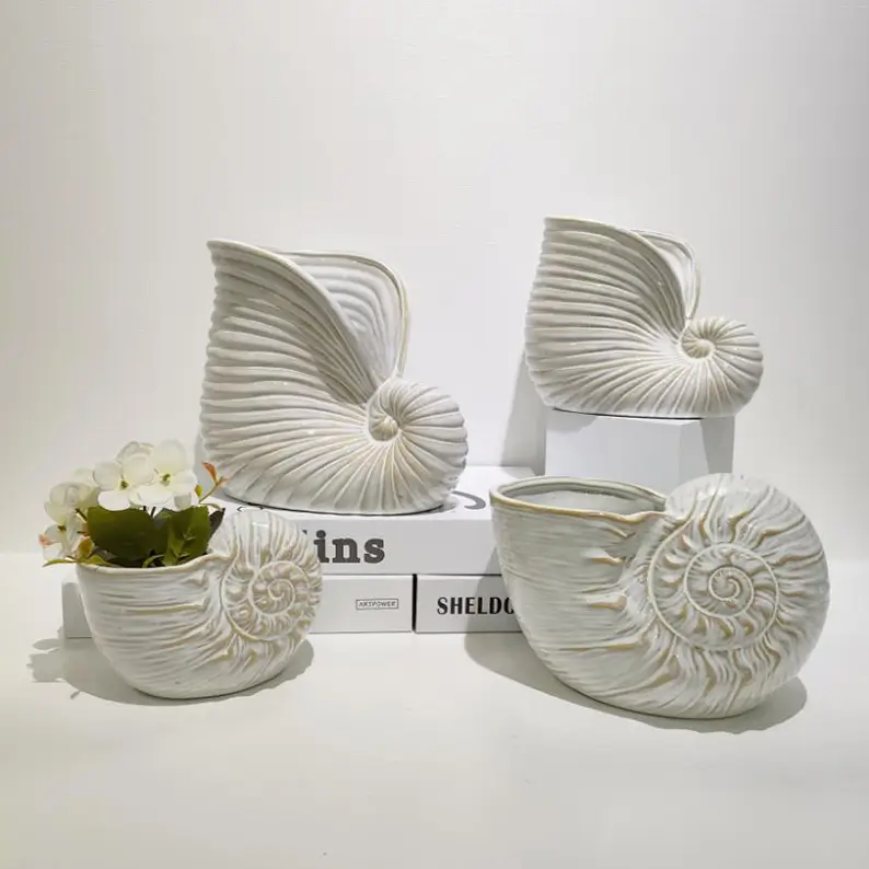 Functional ocean inspired ceramic decor collection combining candle holders, storage containers and floral display applications with artistic shell designs