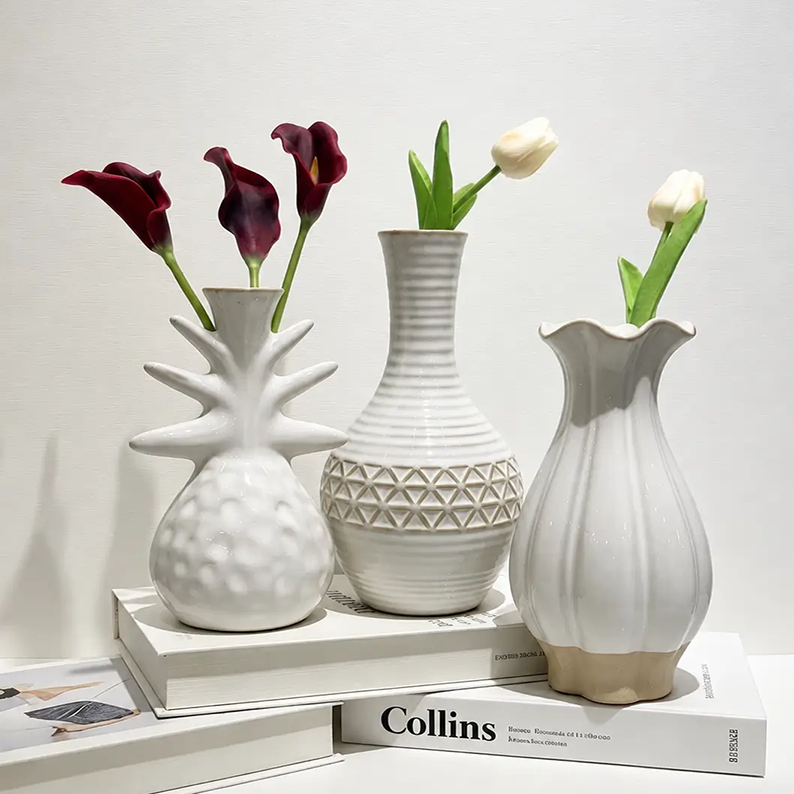 Glazed ceramic vases arranged with fresh flowers for modern interior decoration and elegant home styling