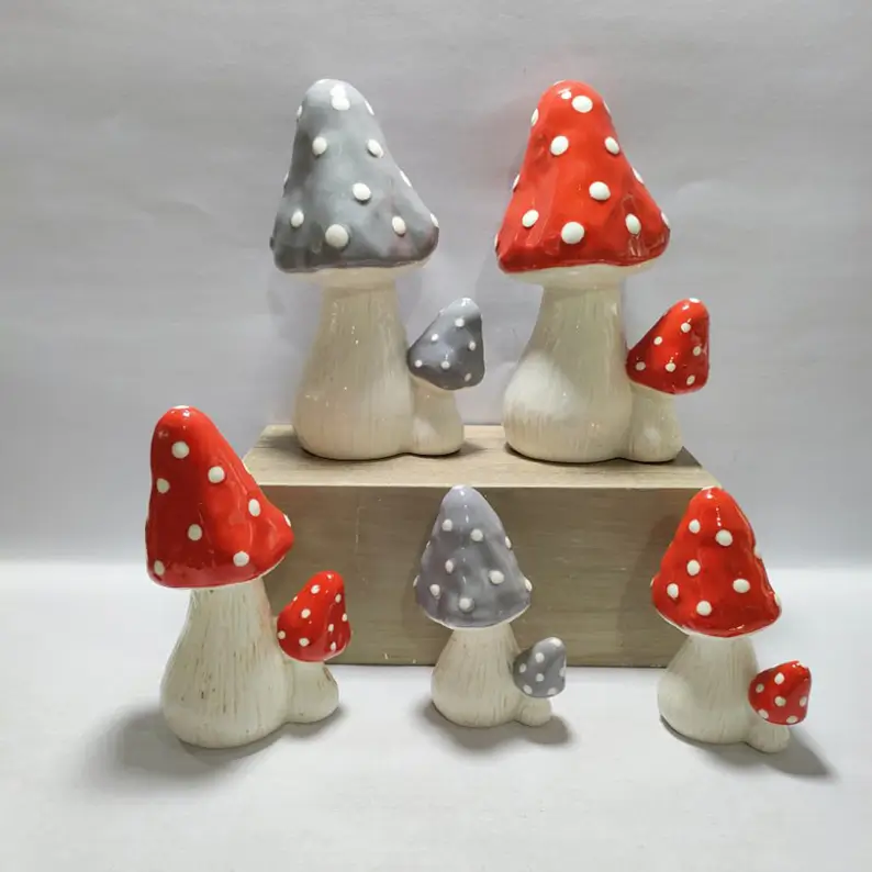 Hand painted ceramic mushroom decor featuring unique mushroom forms, handcrafted polka dot details, and artistic ceramic craftsmanship for interior decoration.
