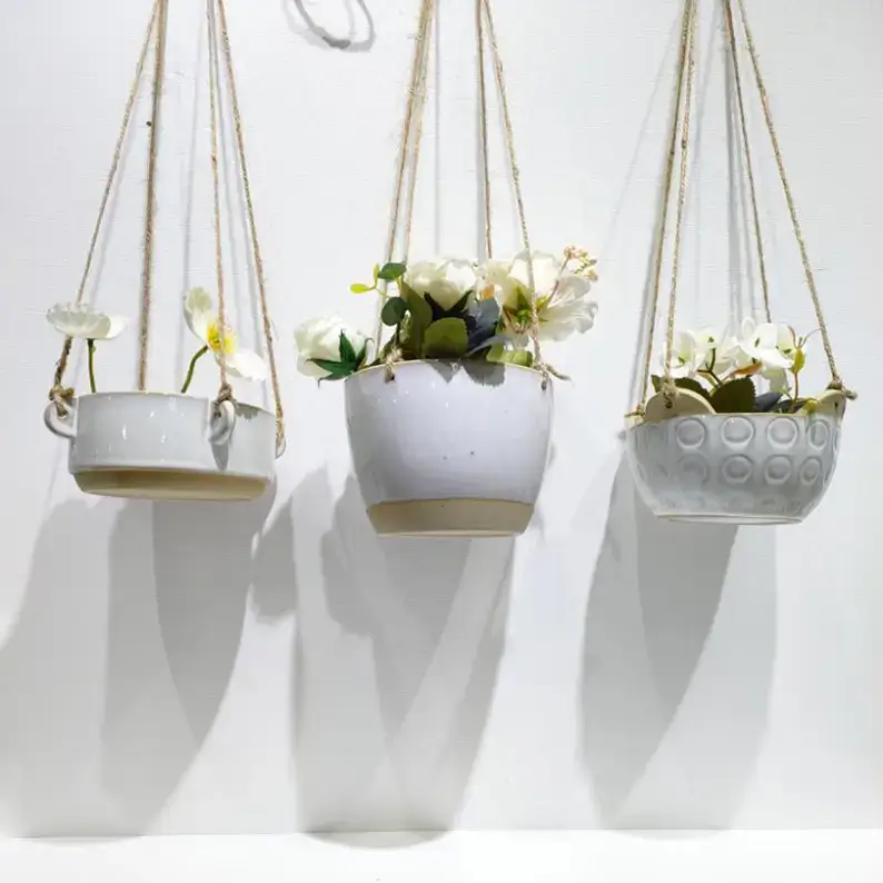 Modern ceramic hanging planters styled with green plants, creating a natural decorative display for windows, living spaces and interior gardens