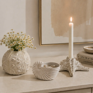 Ocean inspired ceramic decor collection combining shell vase, storage container and candle holder functions with artistic coastal design.