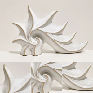 Ocean inspired ceramic shell sculpture with spiral form and organic texture, creating an artistic decorative accent for modern interior spaces.