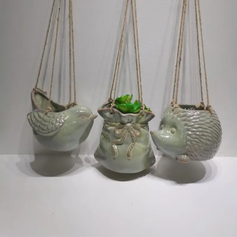 Patterned ceramic hanging planter with reactive cyan glaze effects and decorative surface details
