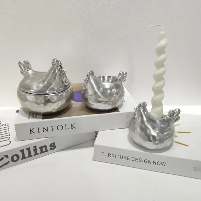 Silver electroplated ceramic chicken set featuring a lidded storage container, open container, and candle holder with matching sculptural chicken forms.