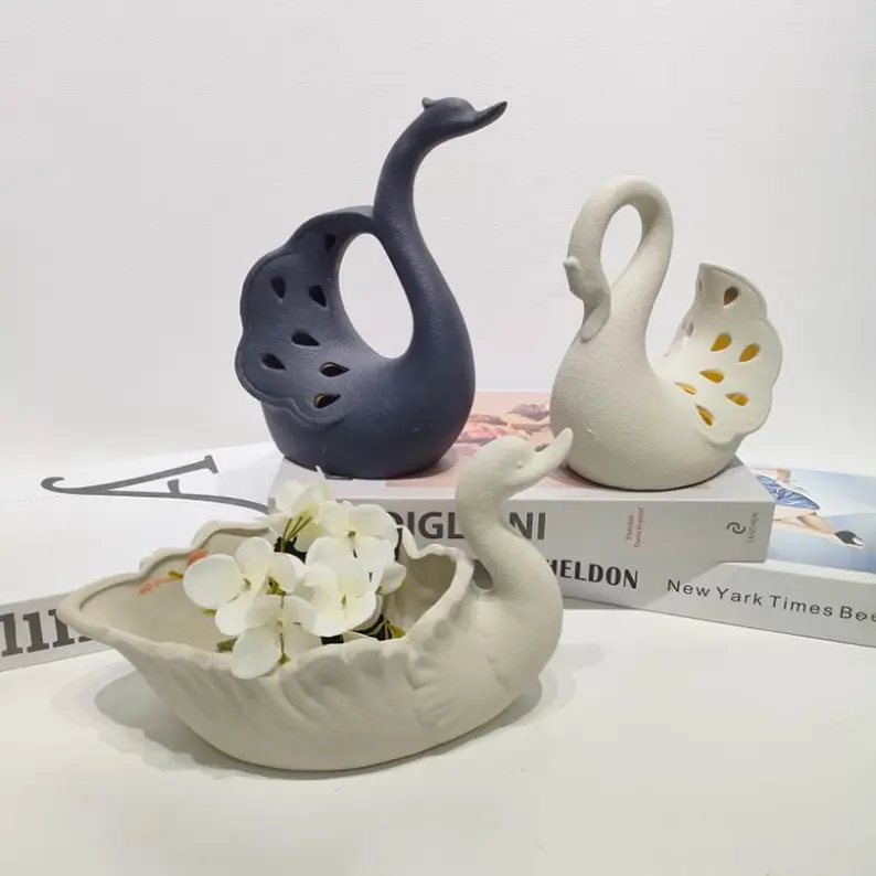 Swan ceramic containers used as decorative storage pieces for jewelry and small accessories with a romantic gift-inspired design.