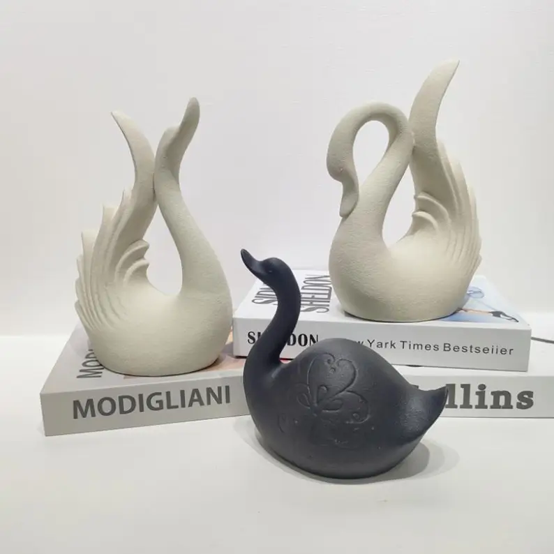 Textured matte swan ceramic pieces in black and white finishes showing different surface effects and color options for seasonal styling.