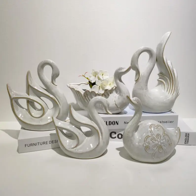 Collection of white swan ceramic ornaments featuring different sculptural forms and artistic silhouettes for Valentine’s Day and wedding decoration.