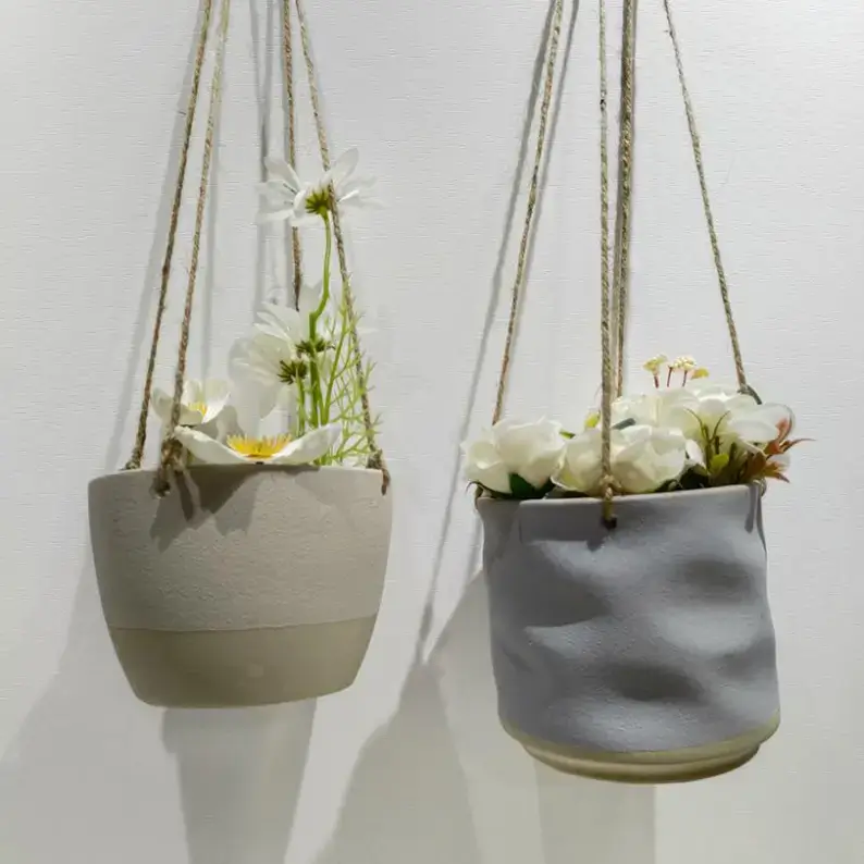 Ceramic hanging planters with embossed and textured surfaces, showcasing unique craftsmanship and decorative patterns for modern plant display.