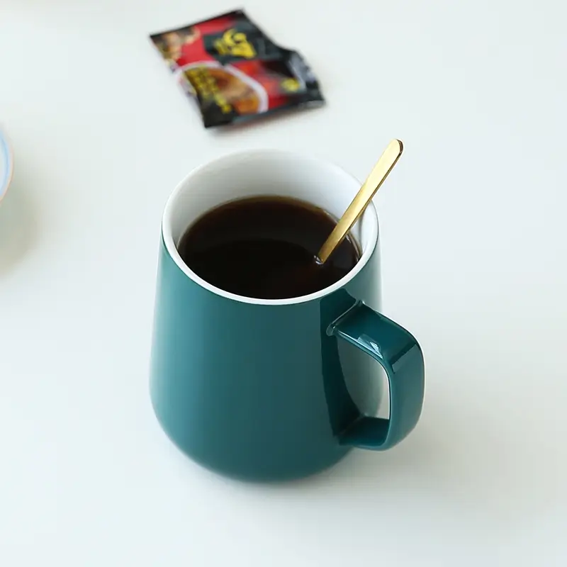 Ceramic mug with spoon used for coffee serving showing practical daily drinkware use.