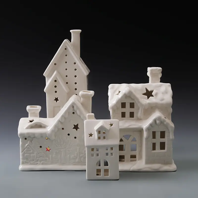 White ceramic Christmas houses with illuminated windows and varied architectural forms for festive village displays